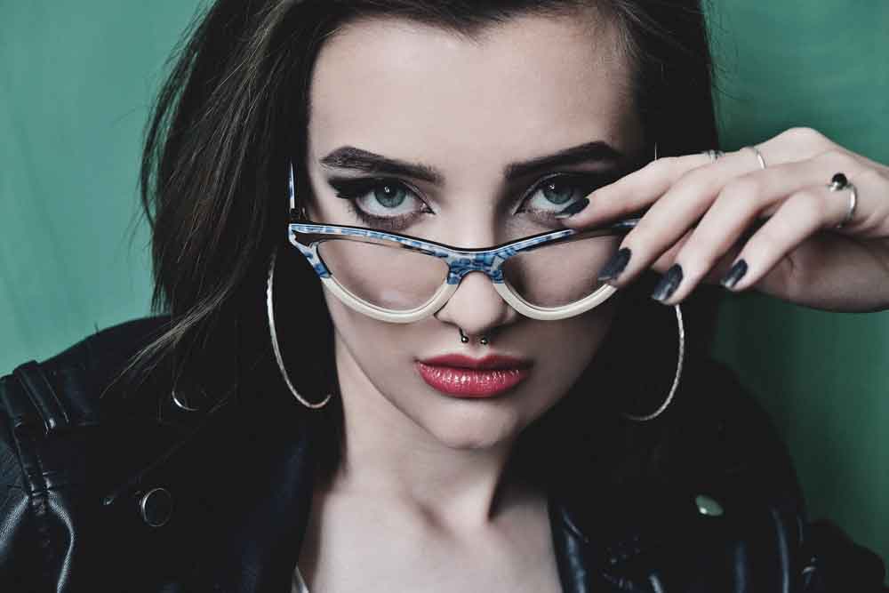 Model wearing luxury cat eye glasses and looking over the top of them