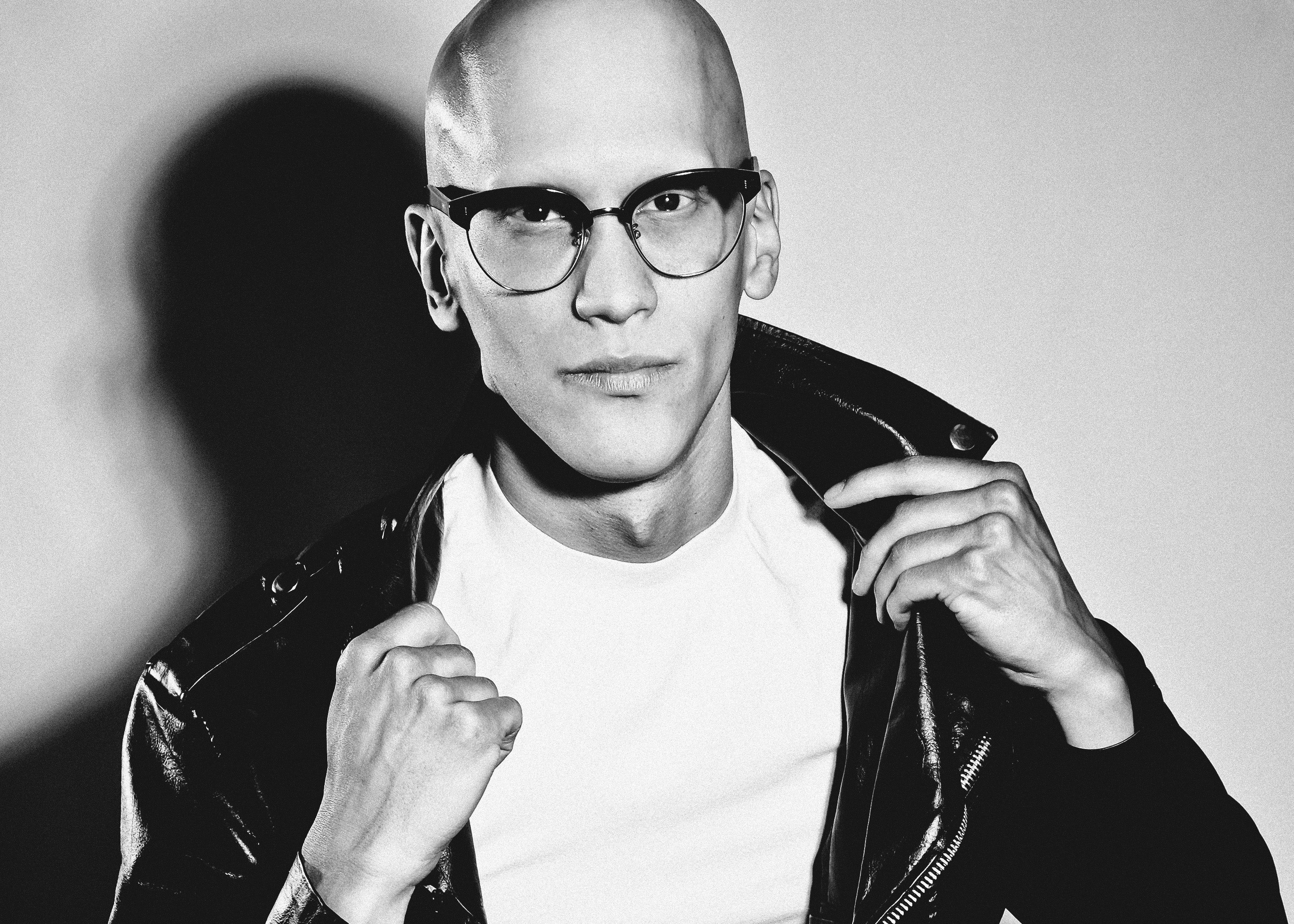 Man wearing 1950s browline glasses, white T & leather jacket.